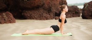 Una mujer haciendo yoga en la playa