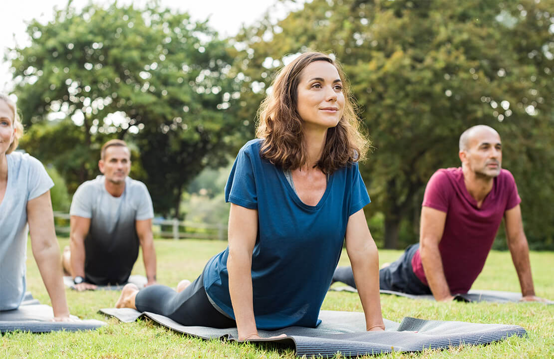 Un grupo de personas haciendo yoga en un parque